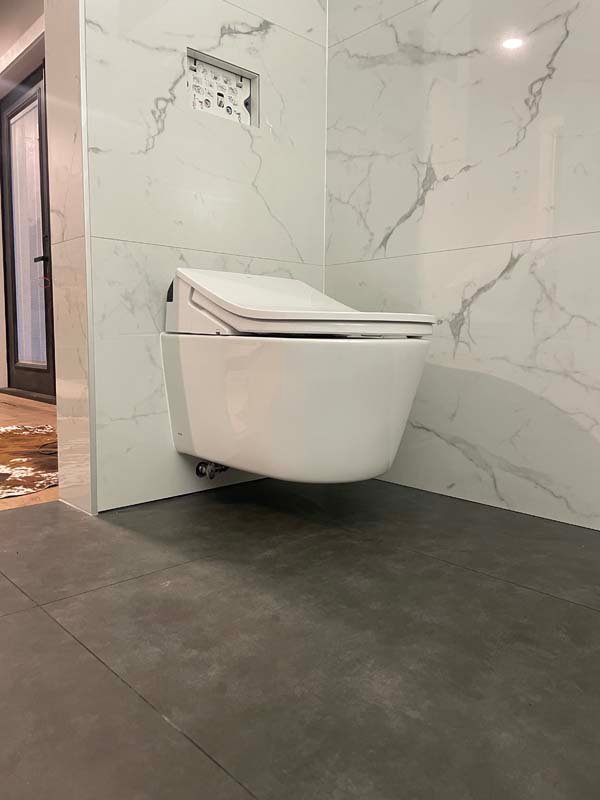 Modern wall-mounted toilet in a marble bathroom