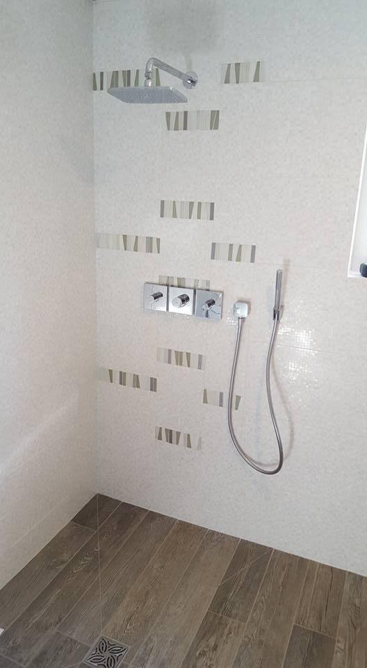 Modern bathroom with wall-mounted shower and decorative tiles