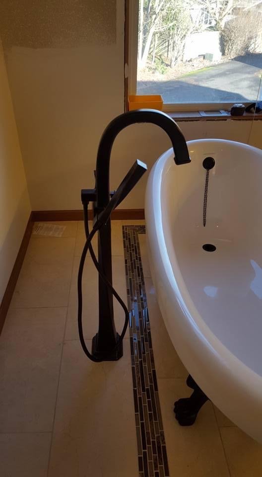 Modern bathroom with freestanding tub and black faucet