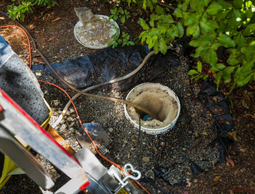 Outdoor pump and hoses setup for construction on gravel