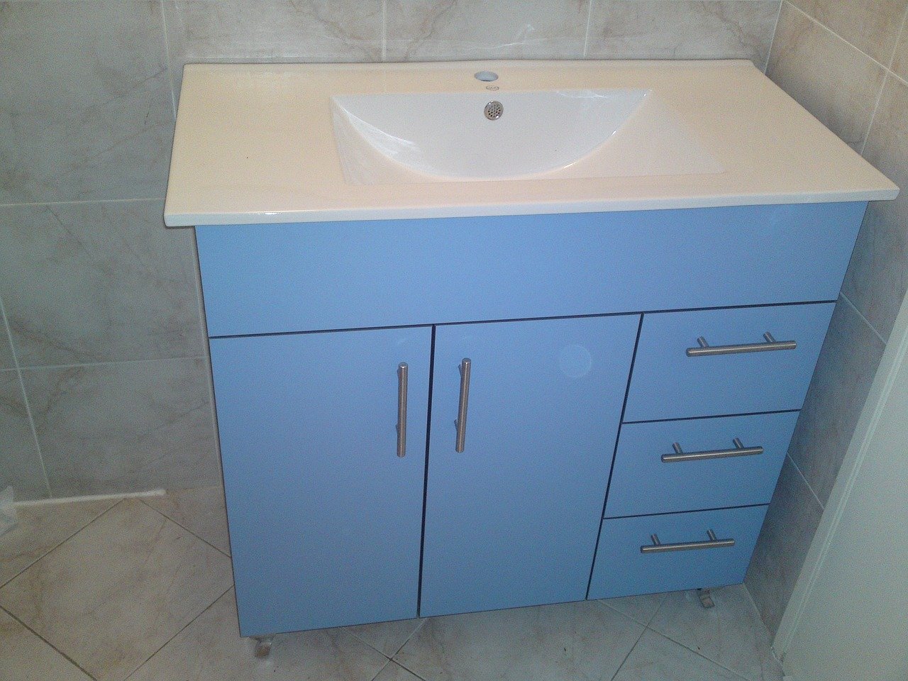 Blue bathroom vanity with sink and storage drawers