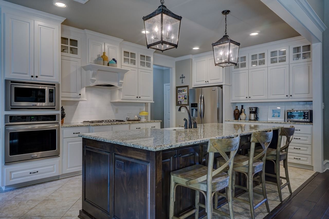 Spacious modern kitchen with white cabinetry and pendant lights