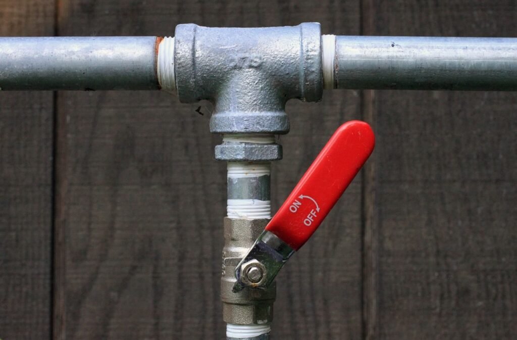 Metal pipe with red on-off valve handle