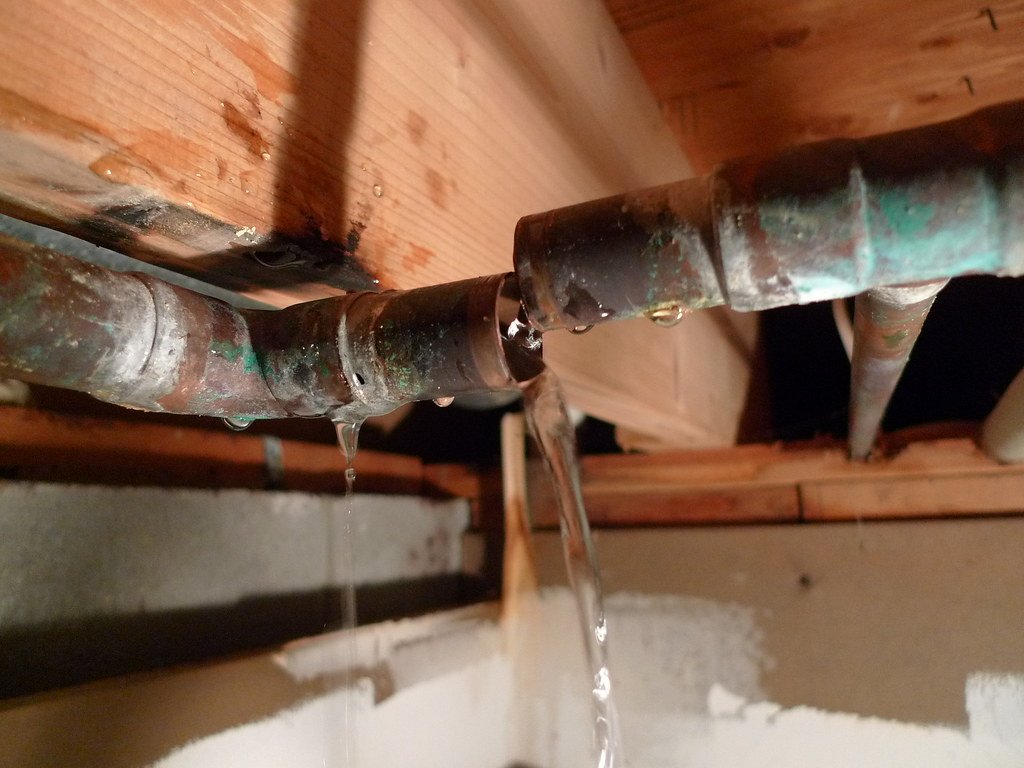 Leaking copper pipes in attic with water dripping