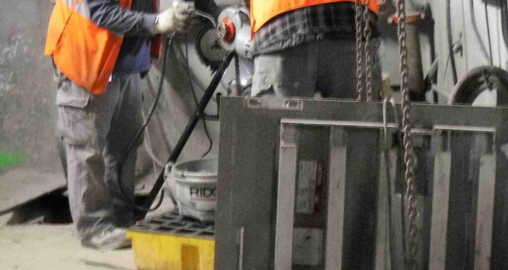 Worker using welding equipment in industrial setting