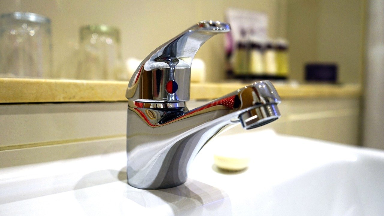 Modern chrome bathroom faucet on white sink